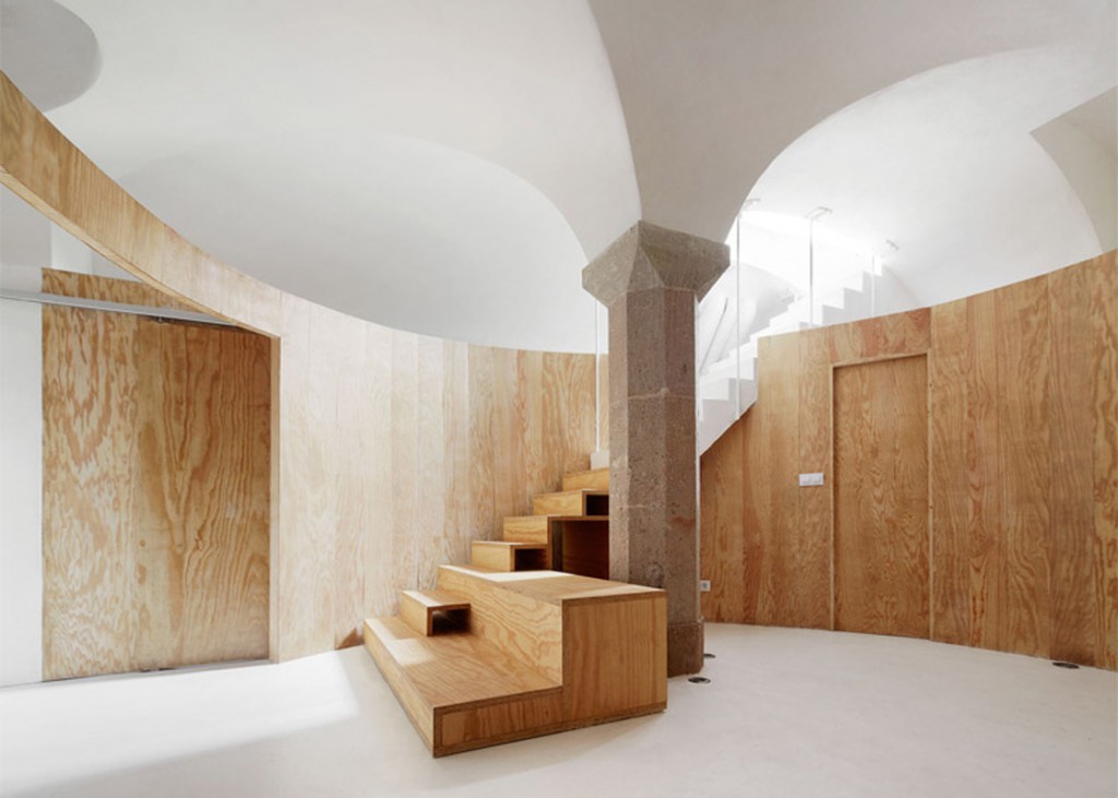 L'appartamento ristrutturato dall'architetto Raul Sanchez a Barcellona con i pannelli di pino lamellare la scala in legno e la colonna in pietra 
